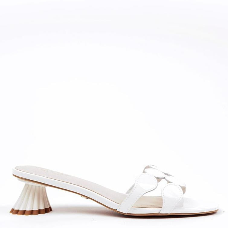 A white dressy patent leather kitten heel sandal with a circle toe strap and a distinctive textured heel.