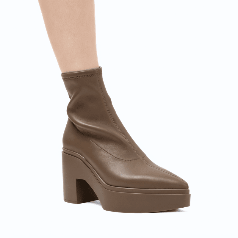 A single brown platform ankle boot with a chunky block heel, shown on a model's foot against a plain white background.