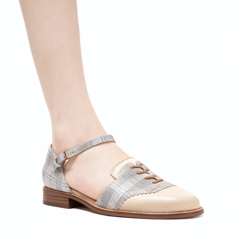 A woman's low-heeled Mary Jane shoe with a beige and gray plaid pattern, featuring a pointed toe, decorative laces, and an ankle strap with a buckle, shown on a model's foot against a white background.