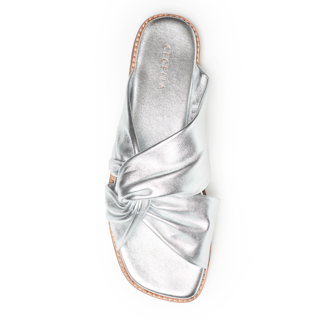 Soft Silver leather sandal with a bow on a white background