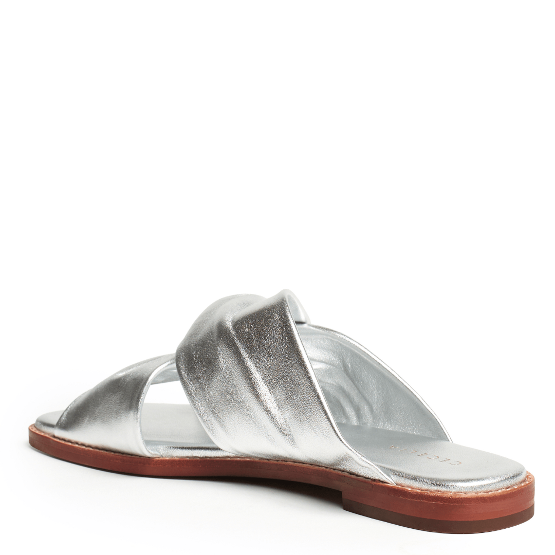 Flat Silver sandal with a brown sole on a white background