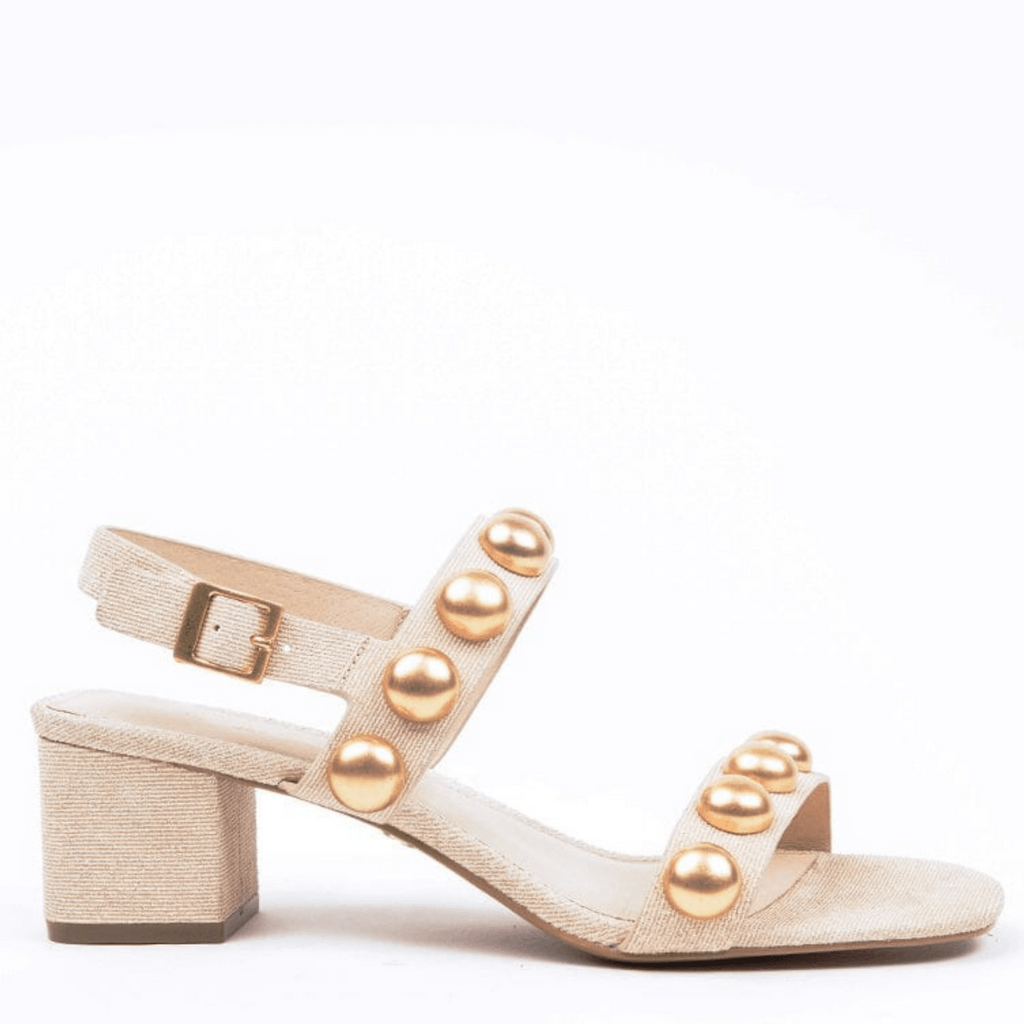 A beige sandal with gold beads, featuring an ankle buckle and a 2-inch heel.
