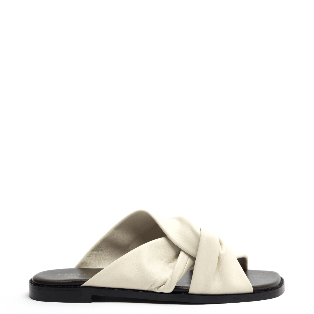 A pair of off-white leather flat sandals with a knotted vamp and a squared toe