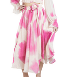 A midi length skirt with a flowy silhouette, featuring a soft ivory base with a delicate pink watercolor print and metallic strands, with an elastic waistband.